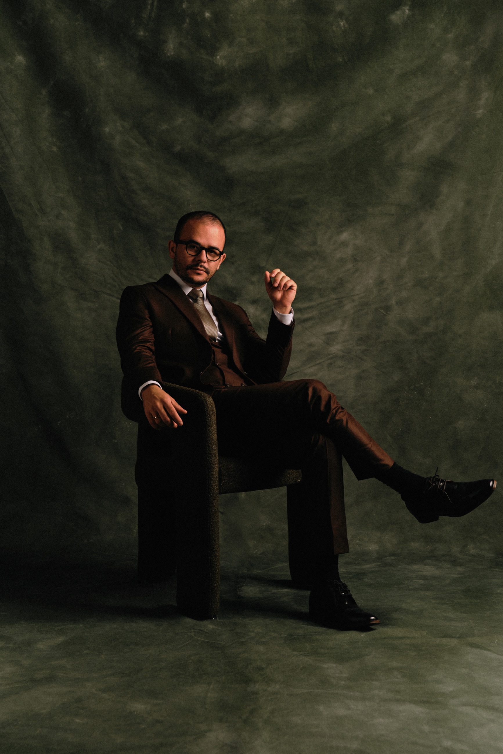 Dr. André sentado em cenário verde